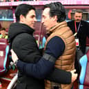 Unai Emery embraces Arsenal manager Mikel Arteta, with Kieran Tierney sitting on the bench in the background.