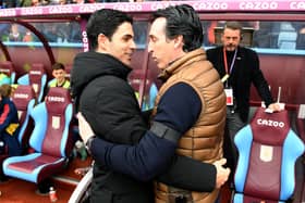 Unai Emery embraces Arsenal manager Mikel Arteta, with Kieran Tierney sitting on the bench in the background.