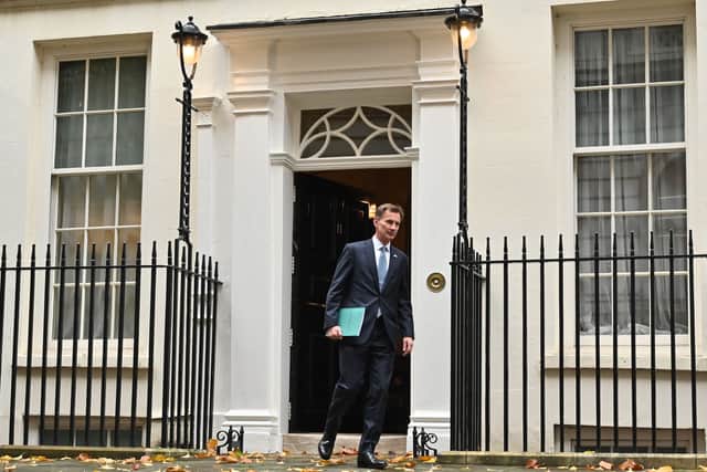 Britain's Chancellor of the Exchequer Jeremy Hunt walks out of Number 11 Downing Street 