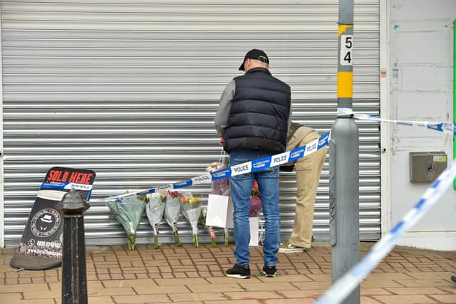 Flowers and police officers at the scene of a violent fatal attack at Heathway Shopping Precinct in Shard End, Birmingham. (Photo - Emma Trimble / SWNS)