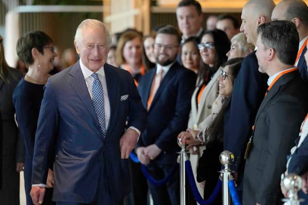 King Charles III (L) chats with staff as he arrives for a visit to the new European Bank for Reconstruction and Development (EBRD)