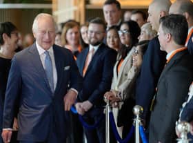 King Charles III (L) chats with staff as he arrives for a visit to the new European Bank for Reconstruction and Development (EBRD)
