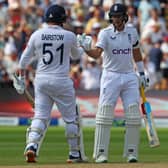 England's Joe Root (R) congratulates England's Jonny Bairstow (L) on reaching his half century during play on the opening day of the first Ashes cricket Test match between England and Australia at Edgbaston in Birmingham