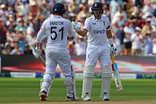 England's Joe Root (R) congratulates England's Jonny Bairstow (L) on reaching his half century during play on the opening day of the first Ashes cricket Test match between England and Australia at Edgbaston in Birmingham