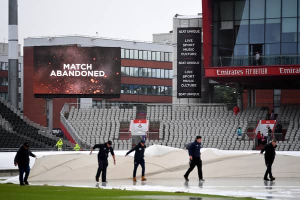 The groundstaff move the covers as the big screen displays that play has been abandoned at the LV= Insurance Ashes 4th Test Match between England and Australia at Emirates Old Trafford on July 23, 2023 in Manchester, England. (Photo by Gareth Copley/Getty Images)