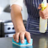 Close Up Of Worker In Restaurant Kitchen Cleaning Down After Service