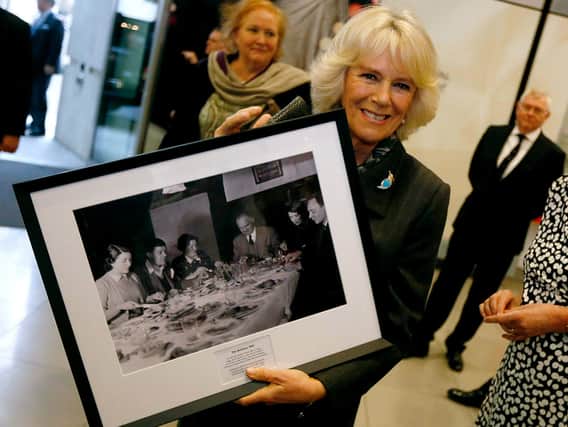 Queen Camilla poses with a picture of the original “Archers” radio soap cast(Photo by Luke MacGregor - WPA Pool/Getty Images)