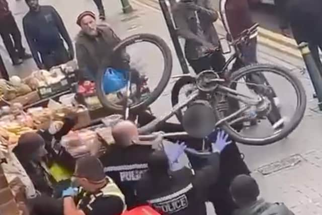 Officers attempt to push back the man charging them with  BICYCLE in Villa Road, Lozells