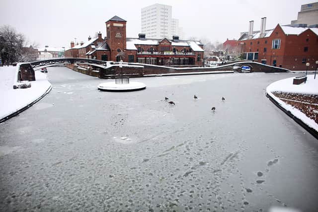   A member of the public makes their way across a snow covered Brindley Palce Canal Basin on January 13, 2010 in Birmingham