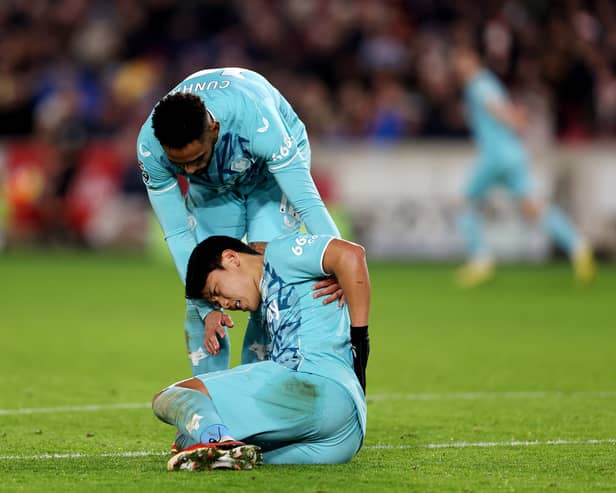 Hwang Hee-Chan of Wolverhampton Wanderers is seen injured while being consoled by Matheus Cunha of Wolves. He could miss the game against Everton at the weekend. (Photo by Alex Pantling/Getty Images)