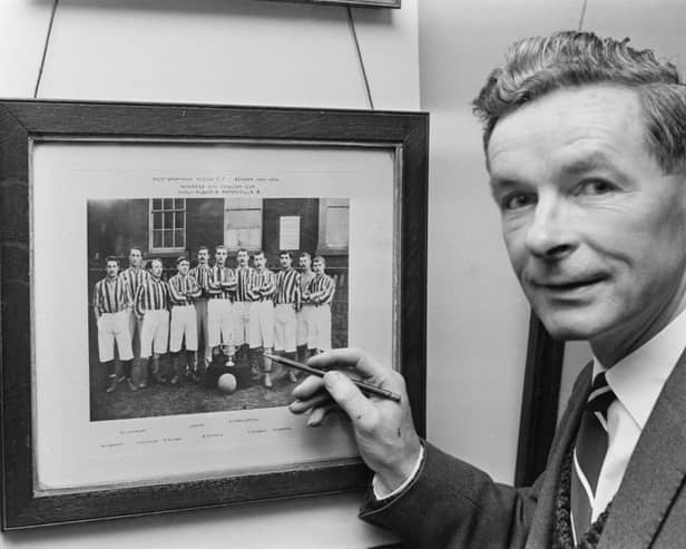 Former footballer Jimmy Hagan (1918 - 1998), manager of West Bromwich Albion, with a photograph of the team for the 1891-1892 season, UK, 4th December 1965. 