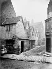 A view into Queen's Head Yard in Birmingham, which is badly run-down. The photograph was possibly taken in the nineteenth century as there is a cart further down the alley and no signs of modernisation