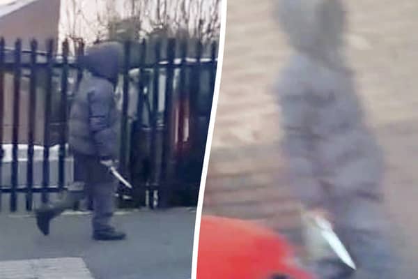moment a hooded knifeman casually walked down the street while brandishing a huge blade near a Birmingham primary school
