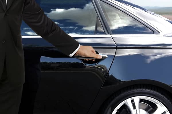 A driver hand opening car door (Adobe image)
