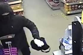 Suspect threatens shop worker with machete.