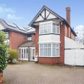 The front of the property, showing the traditional exterior along with a multi-vehicle driveway and garage