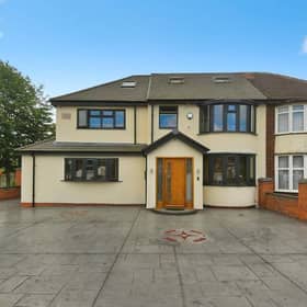 The front of the property with off-road parking for multiple vehicles, giving a clear sense of the home’s size and strong street presence