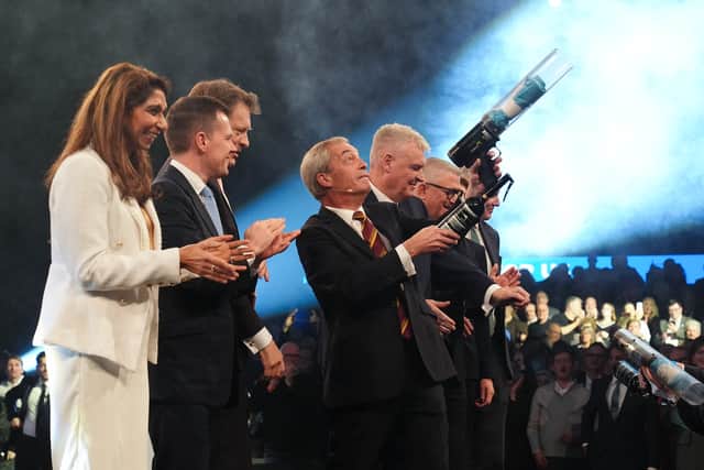 Leader Nigel Farage using a tee shirt cannon during a rally for Reform UK party at the NEC Birmingham