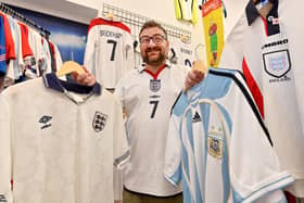 Shaun Owen, of 12th Man Retro, with England and Argentina kits ahead of the World Cup semi-final