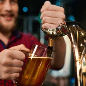 Man pulling a pint behind a bar