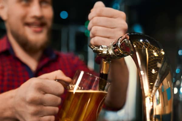 Man pulling a pint behind a bar