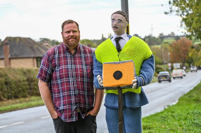 Tom Decker with knitted traffic officer in Fillongley, Warwickshire.