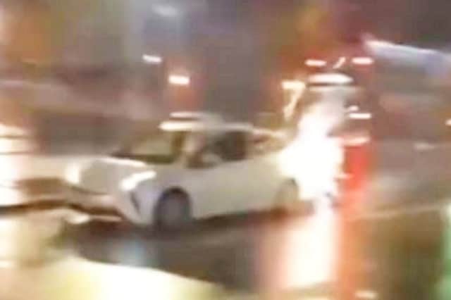 A car in Birmingham, under attack from somebody shooting fireworks at it.