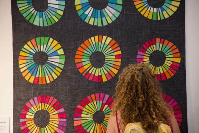 Visitor admiring one of the hundreds of stunning quilts on display