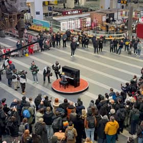 A crowd gathers to watch Bowen playing Take Five during filming of The Piano
