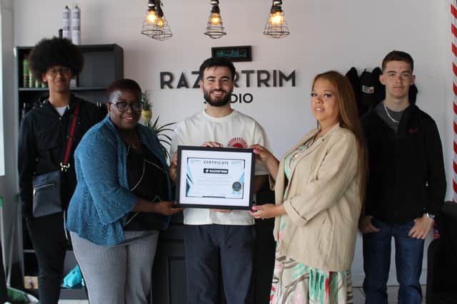 Razwan Amin accepts a certificate from Carol Brown and Nicki Kansara of Erdington Academy PTFA, watched by students Ayub Siraj and Riley Smith, who are doing work experience at his studio