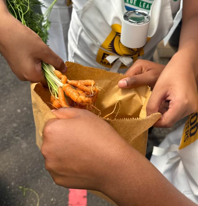 Children bag up carrots at Bullring Open Market