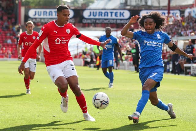 TOUGH DAY: Barnsley's Toby Sibbick (left) and Birmingham City's Tahith Chong battle for the ball at Oakwell. Picture: Isaac Parkin/PA