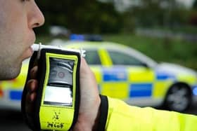 A police officer holds a roadside breathalyser alcohol breath test after taking a sample from a driver 