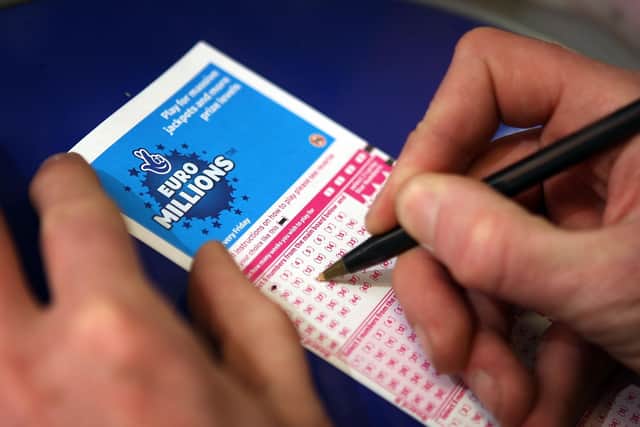 Filling out a National Lottery ticket.  (Photo by Peter Macdiarmid/Getty Images)