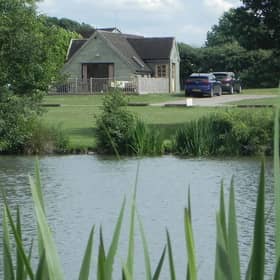 The Skylark Lodge at Brook Meadow viewed from across the campsite's five-acre fishing lake