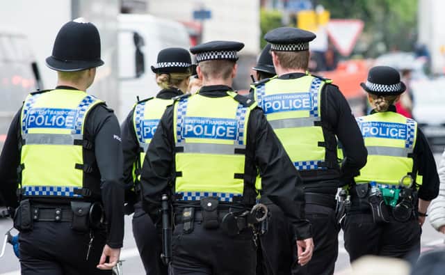 Six British Transport Police officers patrol the street in Highbury, London. 
