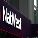 A sign is pictured above the entrance to a branch of a NatWest bank  (Photo by HENRY NICHOLLS/AFP via Getty Images)