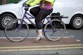 File photo dated 07/08/13 of a person cycling next to a car, as government targets to increase levels of cycling and walking in England are set to be missed, according to a new report.